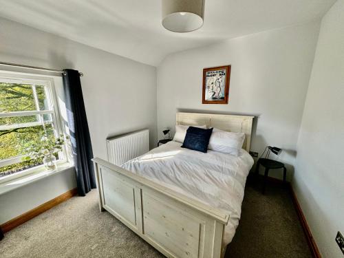 Schlafzimmer mit einem Bett und einem Fenster in der Unterkunft Weavers Cottage, Sleeps 6, outside terrace in Buxton