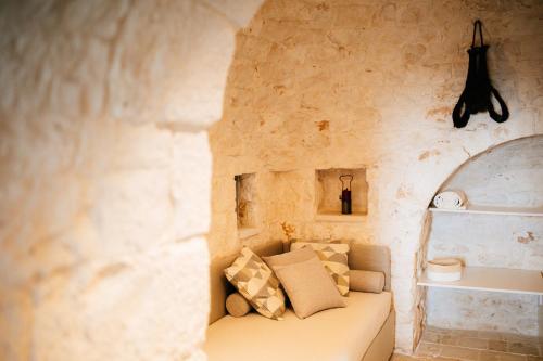 a room with a couch in a stone wall at Borgo Chiancarosa in Putignano