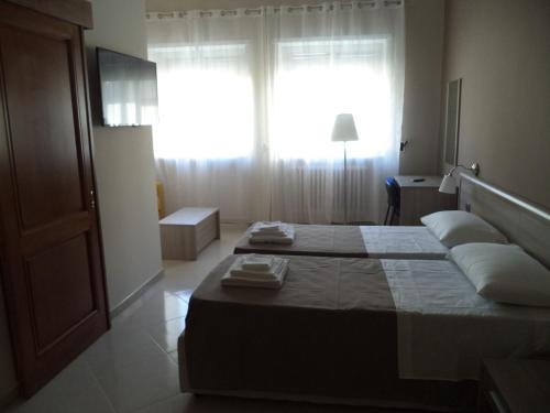 a bedroom with two beds and a window at B&B SALento in San Cesario di Lecce