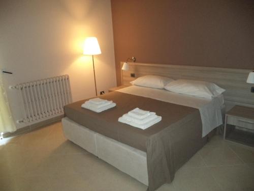 a bedroom with a bed with towels on it at B&B SALento in San Cesario di Lecce