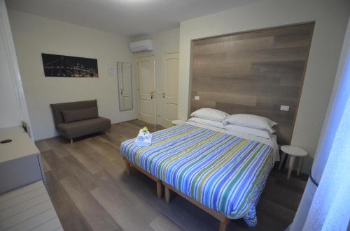 1 dormitorio pequeño con 1 cama y 1 silla en La Coccinella, en Iesi