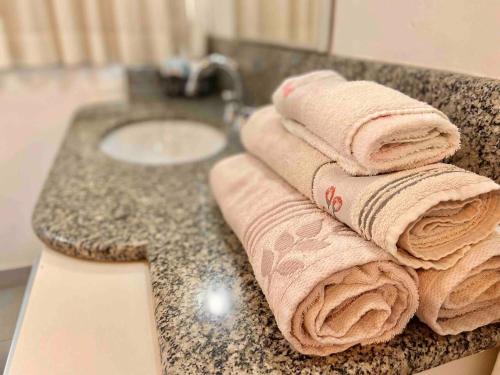 a bathroom counter with towels on a sink at Ocean Flat 606 in Vila Velha