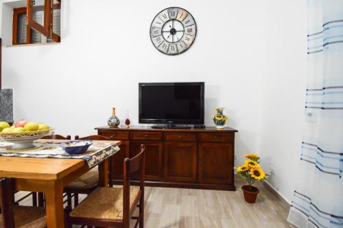 a dining room with a table and a tv on a wall at Casa Giulia Spiaggia 270 m - Appartamento in centro con Cortile in Gioiosa Marea