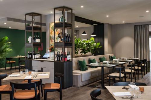 a restaurant with tables and chairs and a bar at Tapestry by Hilton Ambasciatori Hotel in Mestre