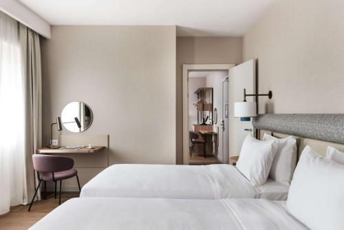 a hotel room with two beds and a mirror at Ambasciatori Hotel Venice Mestre, Tapestry Collection by Hilton in Mestre