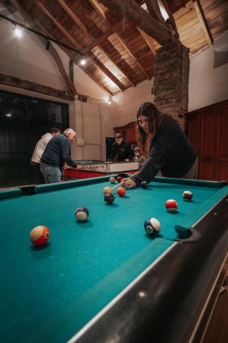 a woman playing pool on a pool table at Apartamentos Lucio Rodinso in Castroverde