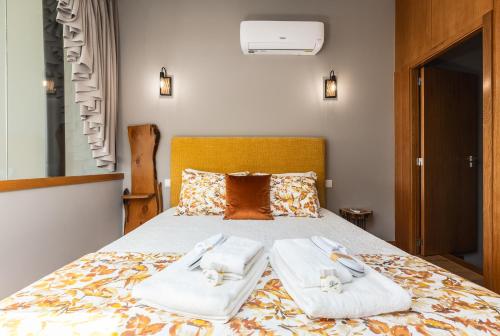 a bedroom with a bed with towels on it at Casas de Bouro 3 Casa do Alecrim in Terras de Bouro