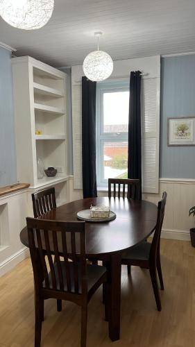 a dining room with a wooden table and chairs at Goncalves place in Bournemouth