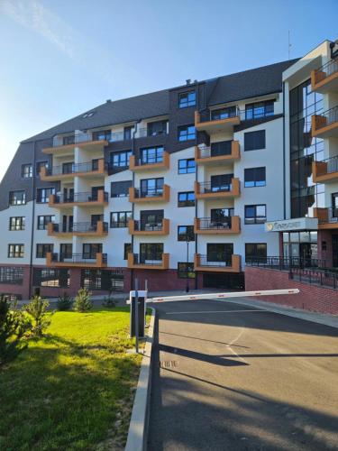 a large apartment building with a parking lot in front of it at The One Apartment Fruške Residence in Vrdnik