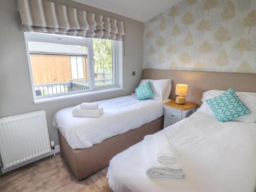 two beds in a small room with a window at 40 Delamere Point in Northwich