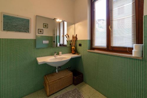 スルツァーノにあるXIO HOMEの緑のタイル張りのバスルーム(シンク、鏡付)