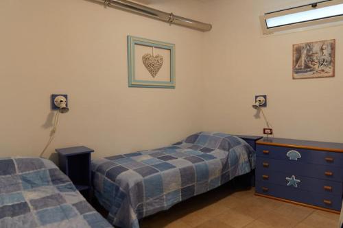 a bedroom with two twin beds and a dresser at Caligo Appartamento incantevole a due passi dal mare in Bordighera