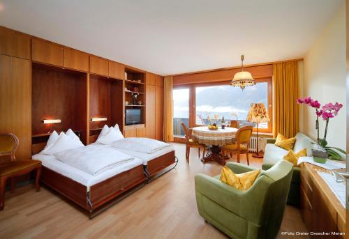 a bedroom with a bed and a table and chairs at Ferienwohnung Spiess in Merano