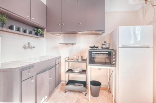 a kitchen with purple cabinets and a white refrigerator at Koukaki Apartment in Athens
