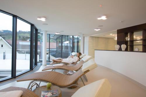 a living room with two people sitting on chairs at Sonnenhof Hotel & Spa in Lautenbach