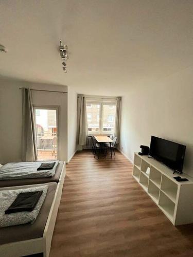 a room with two beds and a television and a table at Stylische 2 Zimmer Wohnung zentral in Osnabrück in Osnabrück