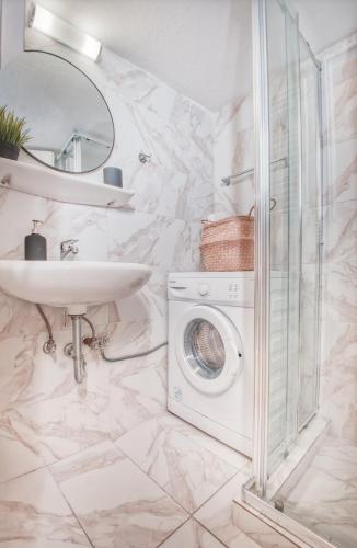 a bathroom with a washing machine and a sink at Koukaki Apartment in Athens