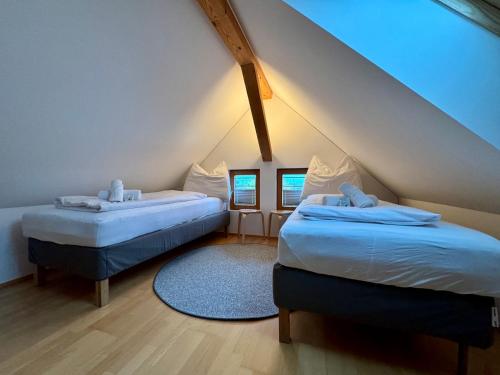 1 dormitorio en el ático con 2 camas y alfombra azul en Charmantes Bauernchalet Alois, en Dornbirn