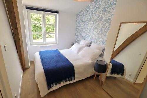 桑利斯的住宿－Maison Downtown Abbaye by La Boîte En Plus，一间卧室配有一张大床,提供蓝白色的毯子