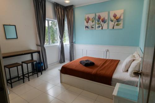 um quarto com uma cama, uma secretária e uma janela em A3A Oastel coLiving em Tanah Rata