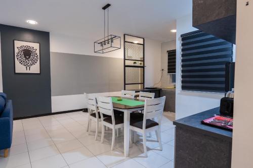 cocina y comedor con mesa y sillas en A3A Oastel coLiving, en Tanah Rata