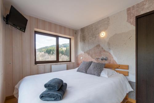 a bedroom with a large bed with a window at Apartment Grizzly - 2 bedrooms - Ski in/out- Les Gets in Les Gets