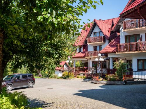 a car parked in front of a building at Hotel Jan in Szczawnica