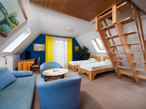 a living room with blue furniture and a staircase at Hotel Jan in Szczawnica