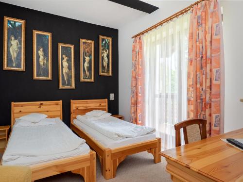 a bedroom with two beds and a table and a window at Hotel Jan in Szczawnica