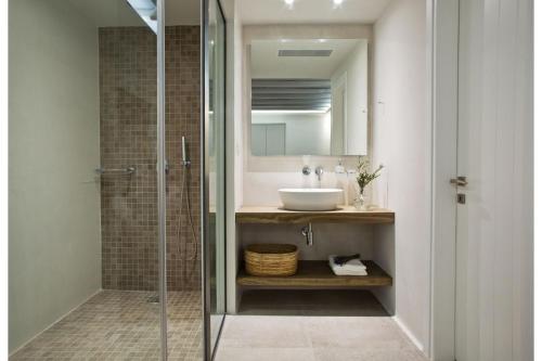 La salle de bains est pourvue d'une douche en verre et d'un lavabo. dans l'établissement Super Luxury Mykonos Villa - Villa La Isla Bonita - Private Gym - Private Pool - 5 Bedrooms - Sea Views, à Dexamenes