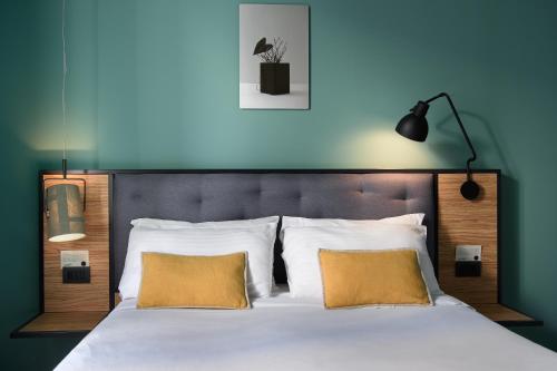 a bedroom with a large bed with two yellow pillows at The Poet Hotel in La Spezia