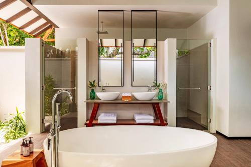a bathroom with two sinks and a tub at NH Collection Maldives Havodda Resort - Stays of 6 nights or more, 50 percent off domestic flights for 2 person in Gaafu Dhaalu Atoll