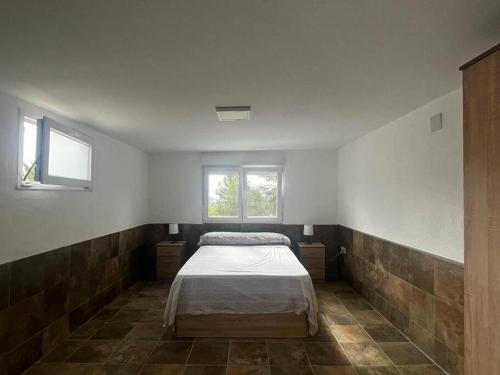 Siete AguasにあるVilla rural Valenciaのベッドルーム1室(ベッド1台、窓2つ付)