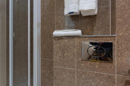 a bathroom with a shower with a towel at Simply Rooms & Suites in London