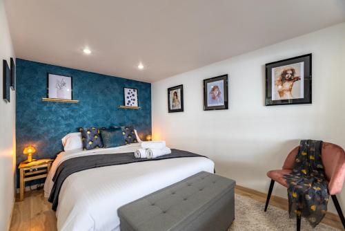 une chambre avec un grand lit et une chaise dans l'établissement Calliopée by Kleidos - Magnifique duplex, Gros Horloge Rouen, à Rouen