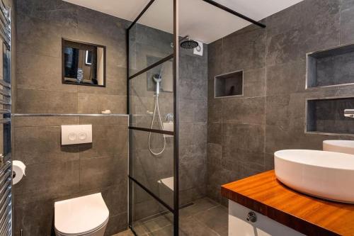een badkamer met een glazen douche en een wastafel bij Gezinswoning met gratis parkeren in Delft