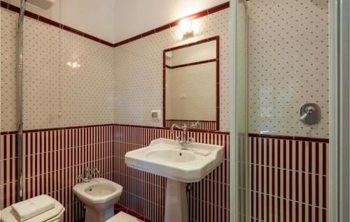 a bathroom with a sink and a toilet and a mirror at 6 Bedroom Awesome Home In Treia in Appignano