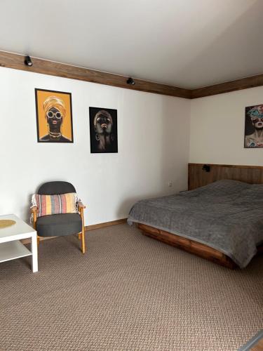 1 dormitorio con 1 cama y 1 silla y cuadros en la pared en Міні-готель, en Kotowsk