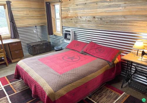 1 dormitorio con 1 cama en una habitación de madera en Pinyon View Murdock Cabin en Verdure