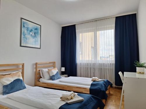 ein Hotelzimmer mit zwei Betten und einem Fenster in der Unterkunft BrightCenterApartment in Graz
