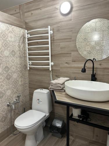 Міні-готель في Kotowsk: حمام مع حوض ومرحاض ومرآة