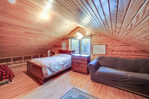 a bedroom in a log cabin with a bed and a couch at Paradise Cottage Trail Access Nearby in Paradise