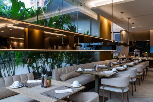 メデジンにあるHotel York Luxury Suites Medellin by Preferredの食卓と椅子、植物のあるダイニングルーム