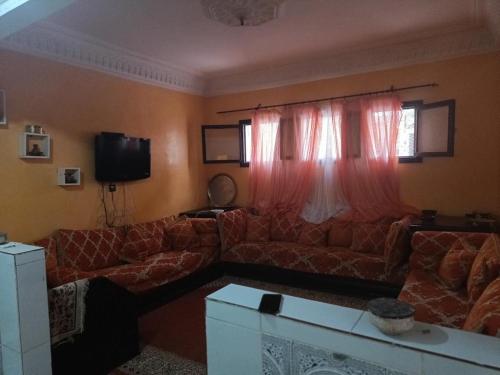 a living room with a couch and red curtains at Friends house in Agadir