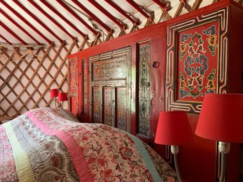 a bedroom with a bed with red walls and two red lamps at Mas Escombelle in Barjac
