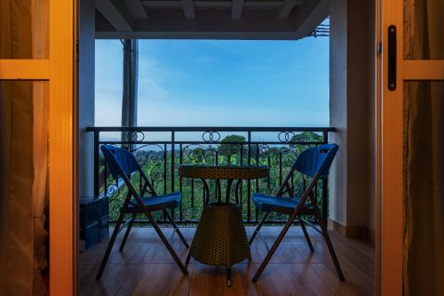 a balcony with a table and chairs and a view at Ambrosia Heights in Entebbe