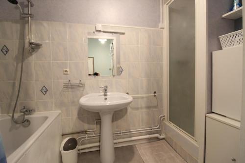 a bathroom with a sink and a mirror and a tub at Appartement dans Maison in Plainfaing