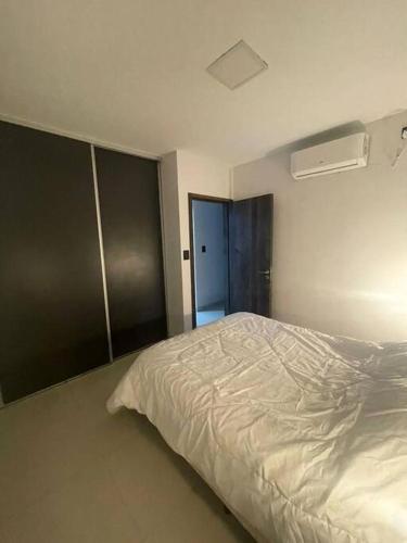 a bedroom with a white bed in a room at DEPARTAMENTO CENTRICO in San Fernando del Valle de Catamarca