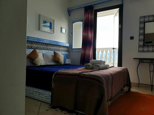 a bedroom with a bed with a window and a bed sidx sidx sidx at Casa Familia in Chefchaouen