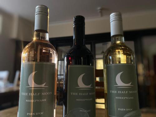 three bottles of wine sitting on a table at Half Moon Inn in Sheepwash